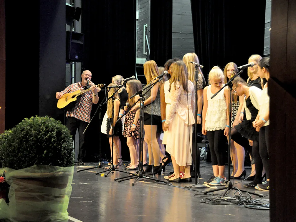 Musizierende und Singende auf der Bühne.